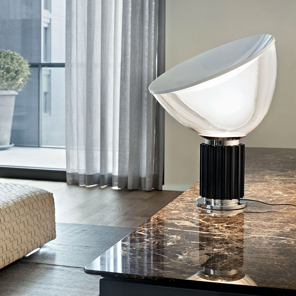 FLOS Taccia Tischleuchte bei lampenonline.de. Die FLOS Taccia LED-Tischleuchte &uuml;bertr&auml;gt die Formensprache der 60er Jahre gekonnt in die Moderne. Ihr markantes Merkmal ist der ausladende Diffusor aus mundgeblasenem, transluzentem Glas. 